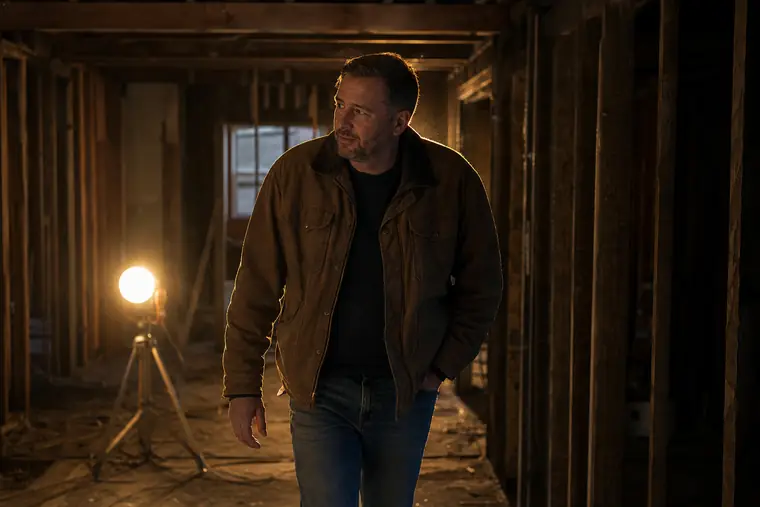 An investor walking through a house mid-renovation with bare studs